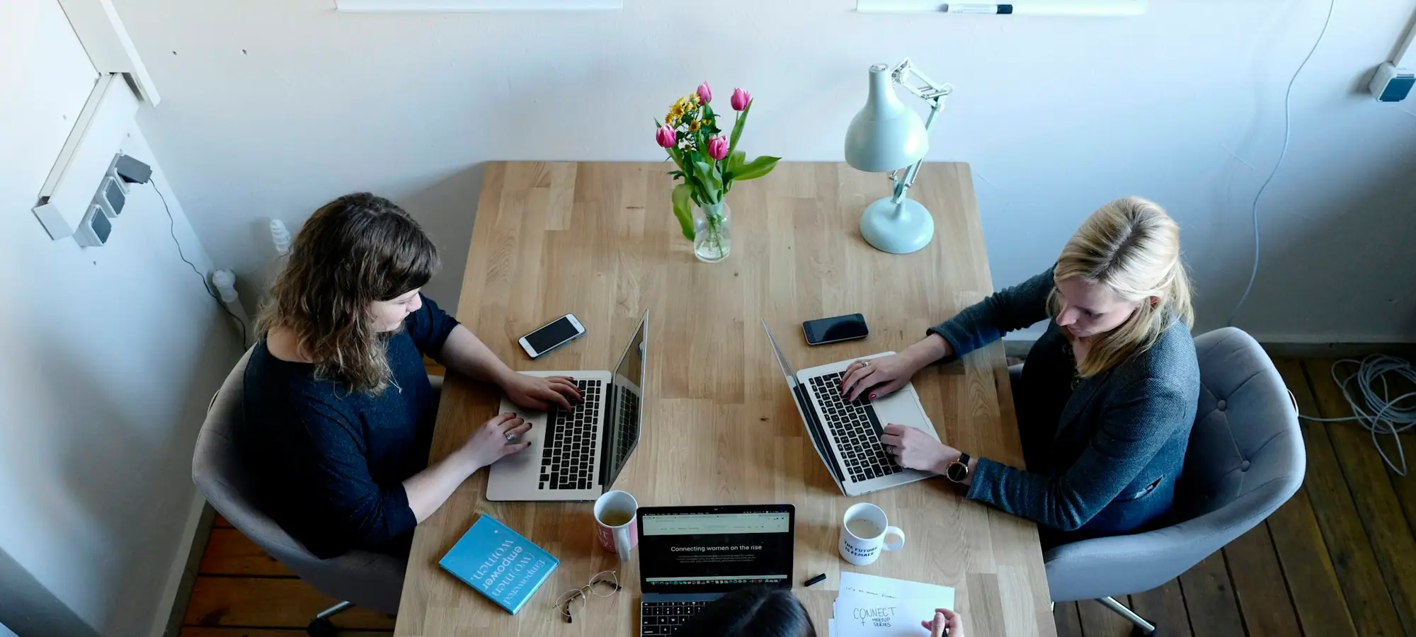 Consultants working together on laptops around a table