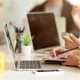 business professional working on a laptop writing notes